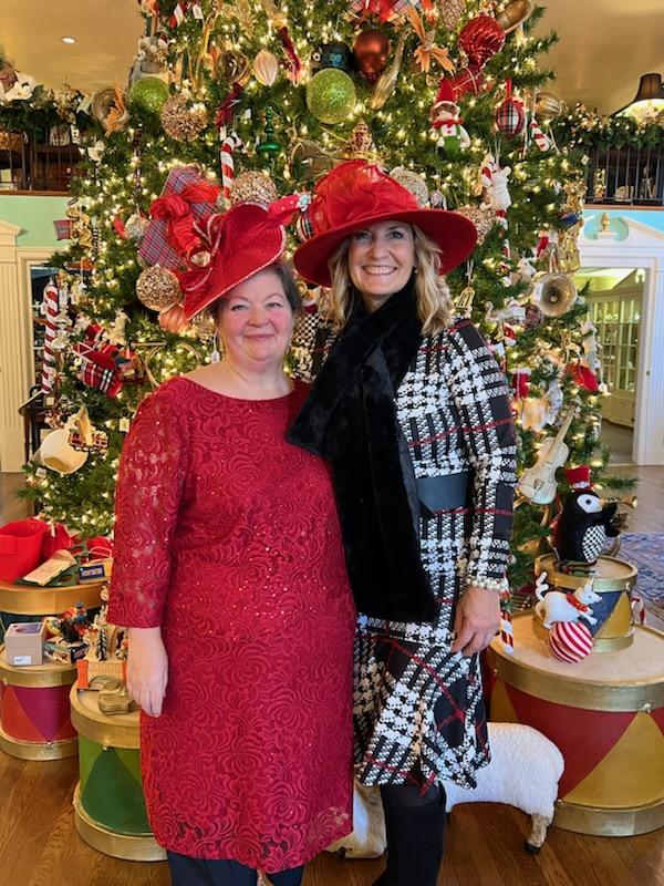 Guests in festive hats beside a Christmas tree